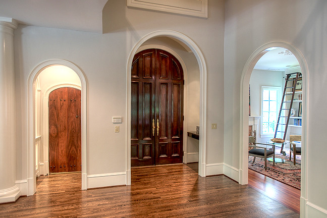 Пример оригинального дизайна: огромная входная дверь в средиземноморском стиле с серыми стенами, паркетным полом среднего тона, двустворчатой входной дверью и входной дверью из темного дерева