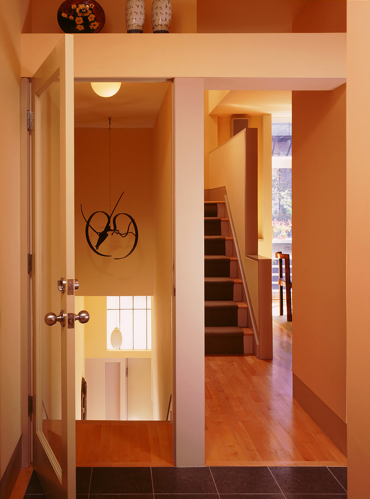 Inspiration pour une grande entrée design avec un couloir, un mur beige, parquet clair, une porte simple et une porte blanche.