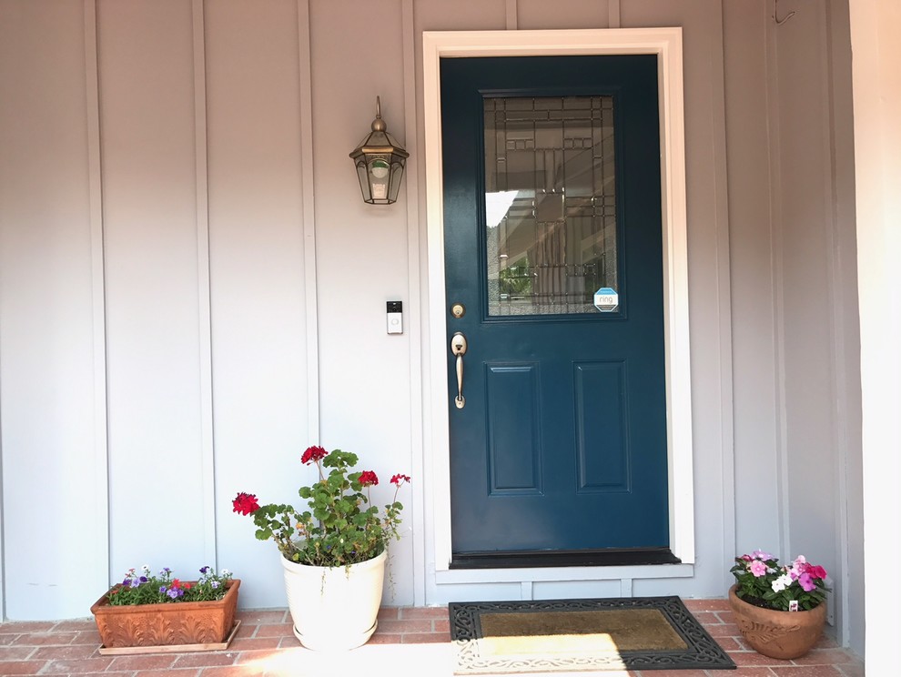 Ejemplo de entrada moderna con paredes grises, suelo de ladrillo, puerta simple, puerta azul y suelo rojo