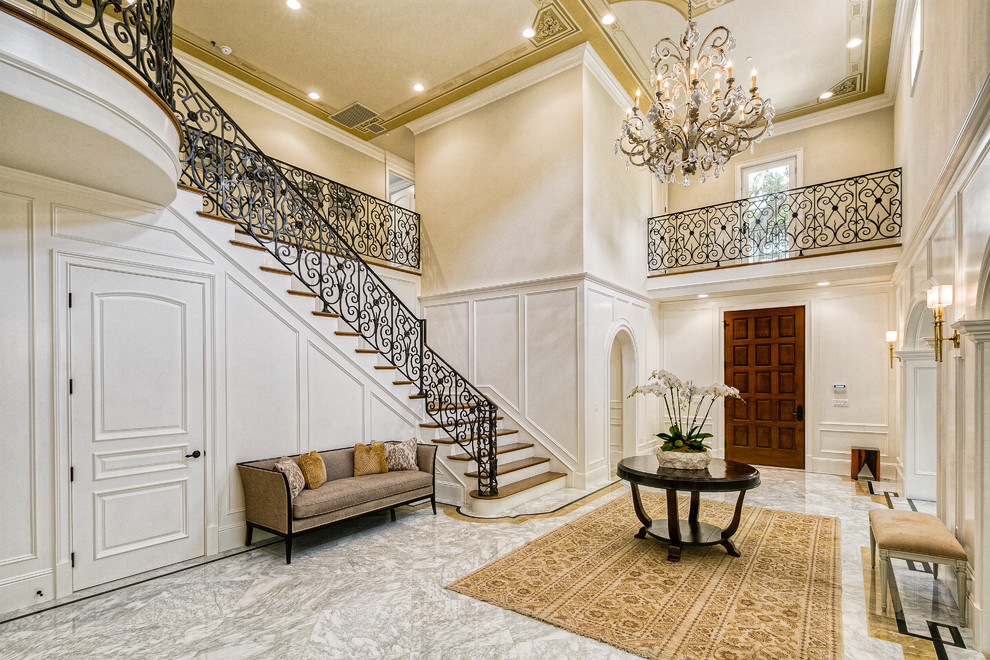 Inspiration for a timeless marble floor and multicolored floor entryway remodel in Los Angeles with white walls and a medium wood front door