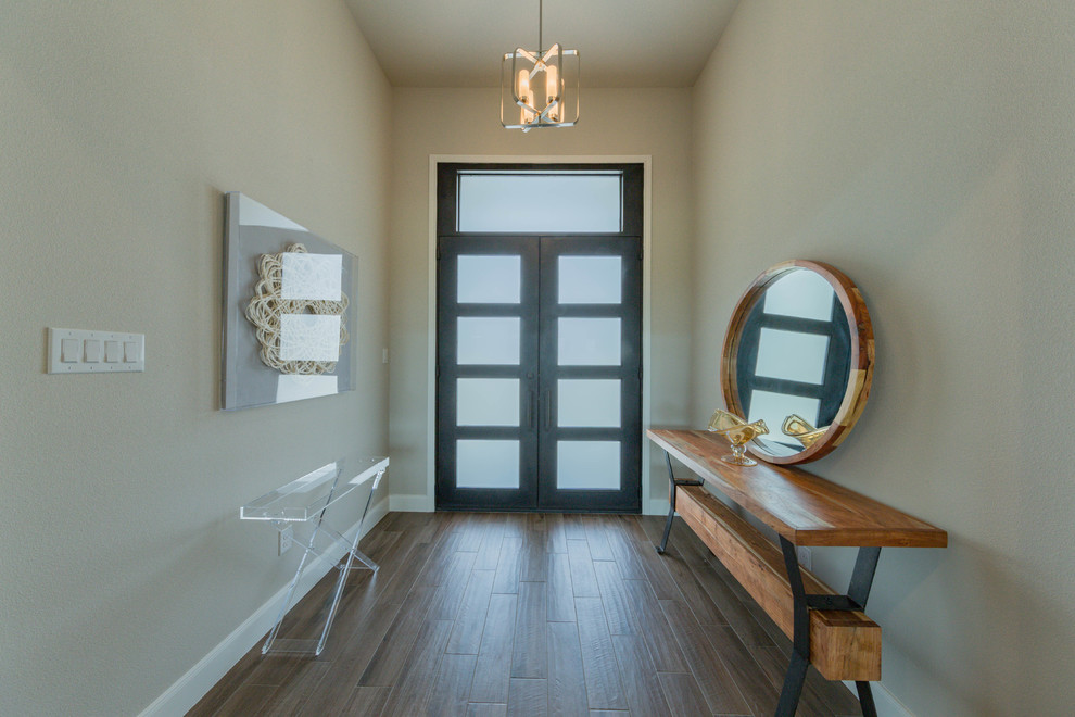 Esempio di un ingresso chic di medie dimensioni con pareti grigie, pavimento in gres porcellanato, una porta a due ante, una porta in metallo e pavimento marrone