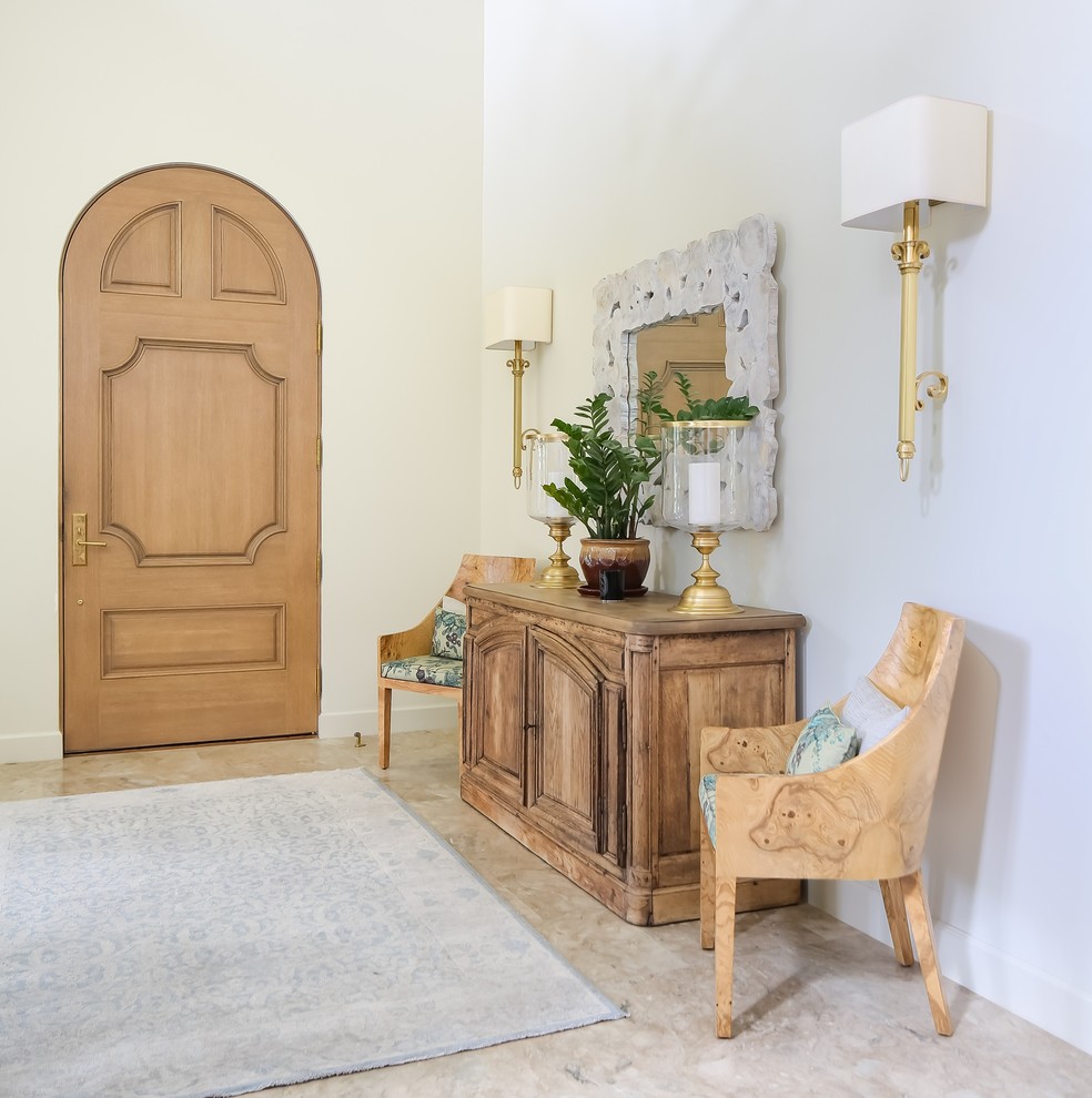 Esempio di un ingresso mediterraneo di medie dimensioni con pareti bianche, una porta singola, una porta in legno chiaro e pavimento beige