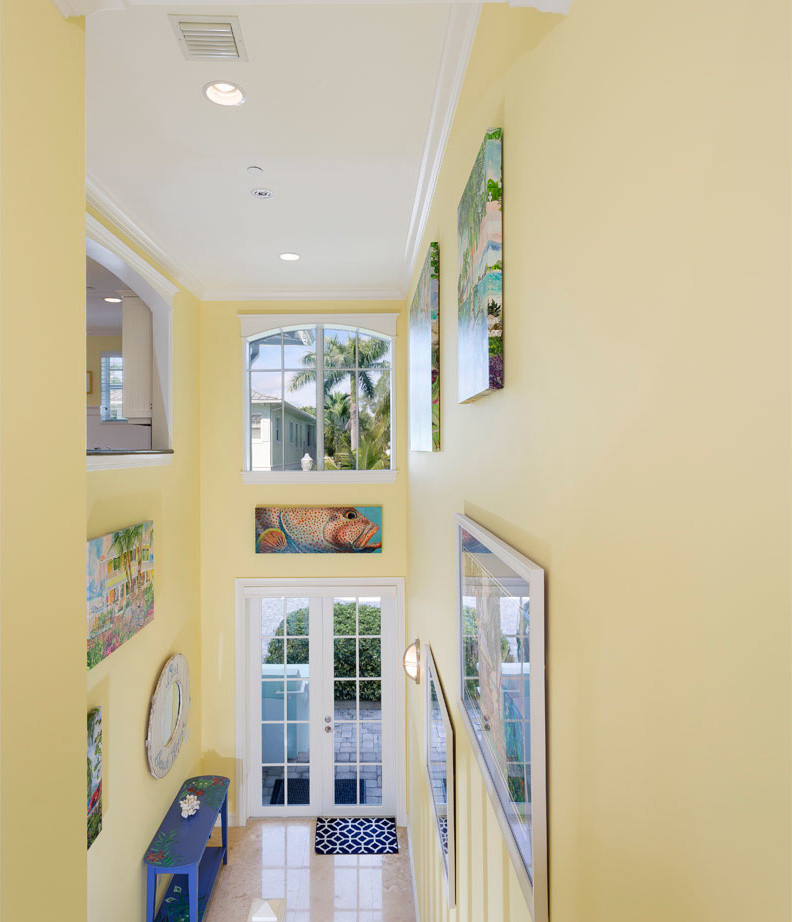 Inspiration för en mellanstor maritim hall, med gula väggar, klinkergolv i porslin, en dubbeldörr, en vit dörr och beiget golv