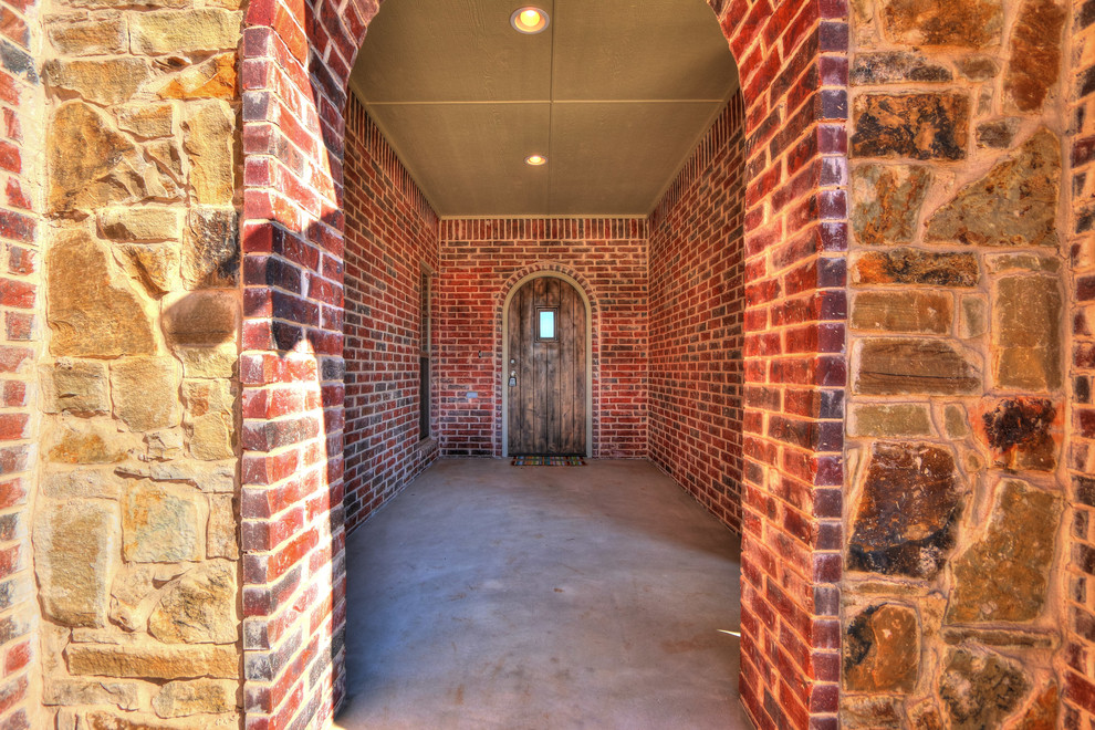 Inspiration pour une porte d'entrée design de taille moyenne avec un mur rouge, sol en béton ciré, une porte simple, une porte en bois brun et un sol gris.