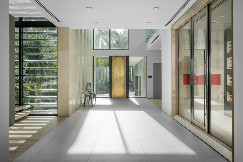 Esempio di un grande ingresso minimalista con pareti bianche, pavimento in cemento, una porta singola e pavimento grigio