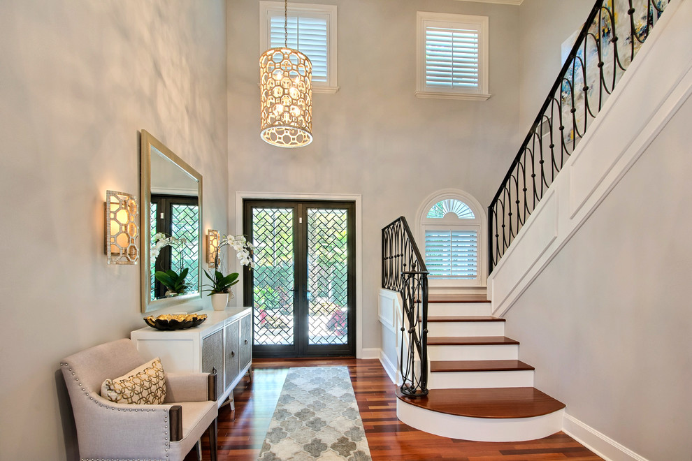 Klassisches Foyer mit grauer Wandfarbe, gebeiztem Holzboden, Doppeltür, Haustür aus Glas und braunem Boden in Miami
