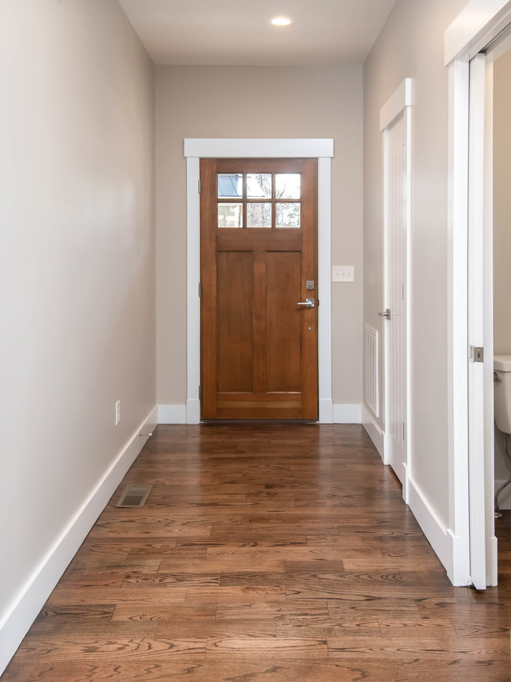 Foto de puerta principal clásica renovada de tamaño medio con paredes grises, suelo de madera oscura, puerta simple, puerta de madera oscura y suelo marrón