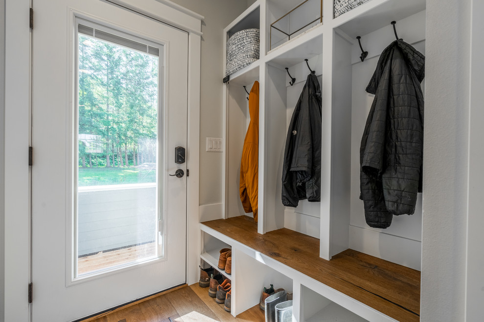 This is an example of a medium sized classic boot room in Seattle with medium hardwood flooring, a single front door, a glass front door and brown floors.