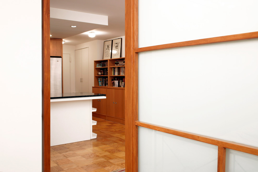 Idées déco pour un petit hall d'entrée moderne avec un mur blanc, un sol en bois brun, une porte simple et une porte blanche.