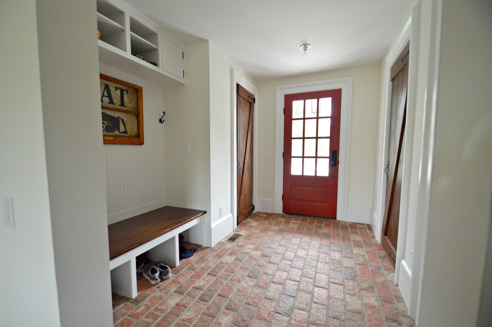Example of a mid-sized cottage brick floor and red floor entryway design in Philadelphia with white walls and a red front door