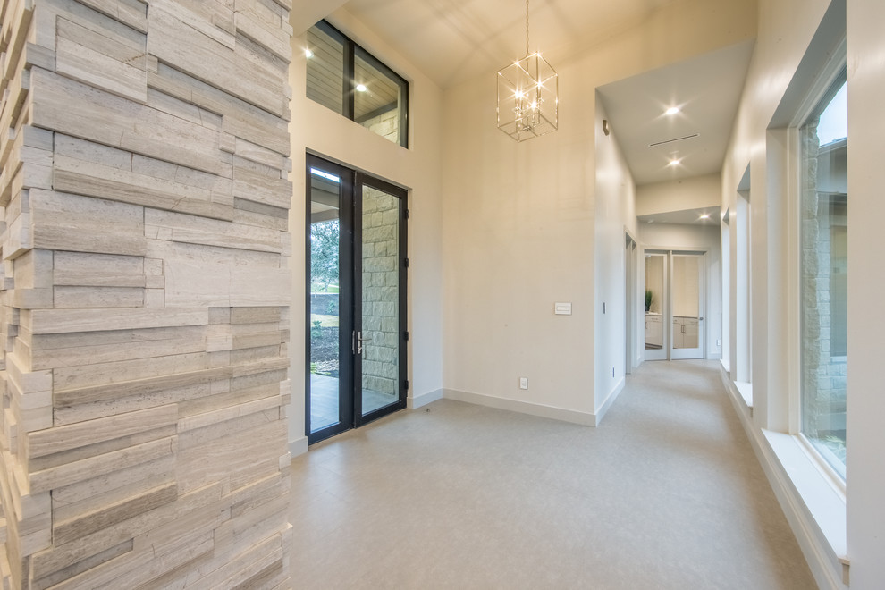 Mid-sized trendy limestone floor entryway photo in Austin with white walls and a glass front door