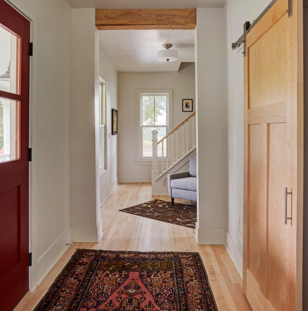 Idee per un piccolo ingresso country con pareti bianche, parquet chiaro, una porta singola e una porta rossa