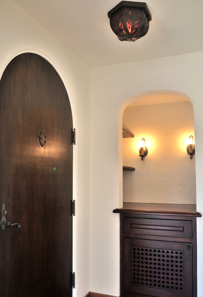 Entryway - mediterranean entryway idea in San Diego with white walls and a dark wood front door