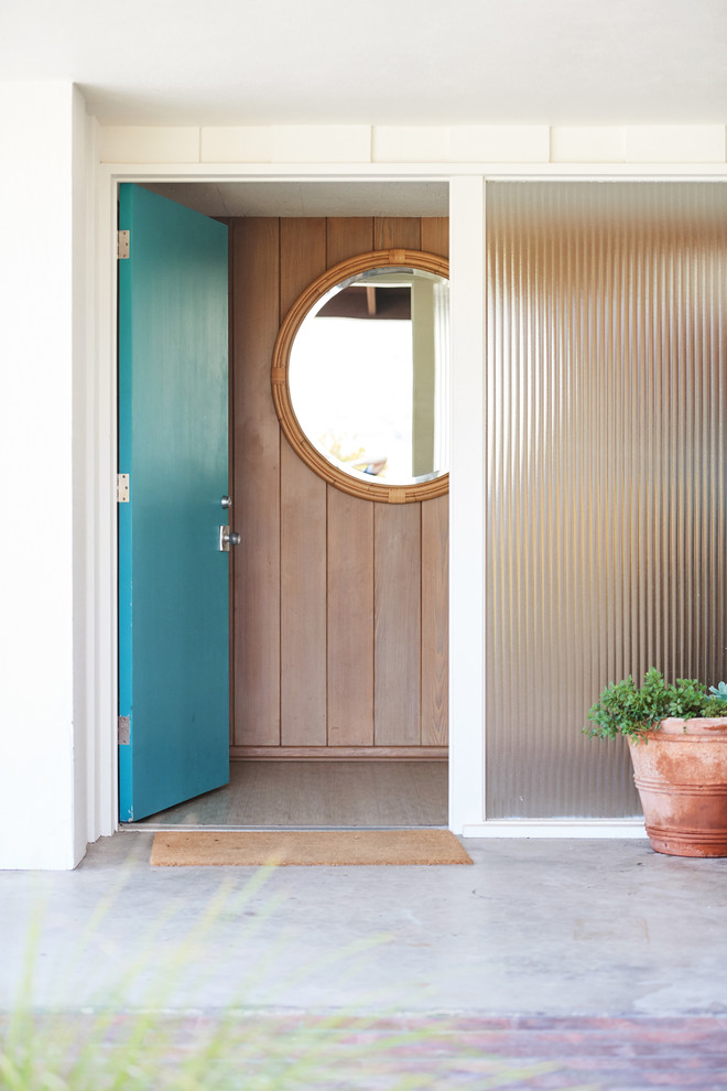 Foto de puerta principal retro de tamaño medio con paredes blancas, suelo de cemento, puerta simple, puerta azul y suelo gris