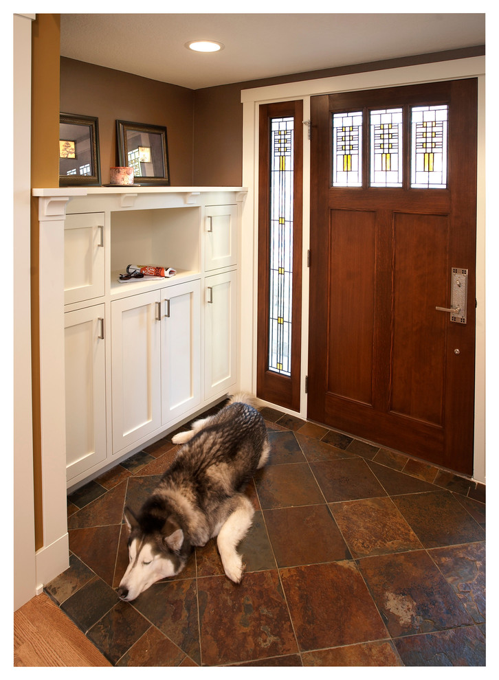 Imagen de distribuidor de estilo americano pequeño con paredes marrones, suelo de pizarra, puerta simple y puerta de madera oscura