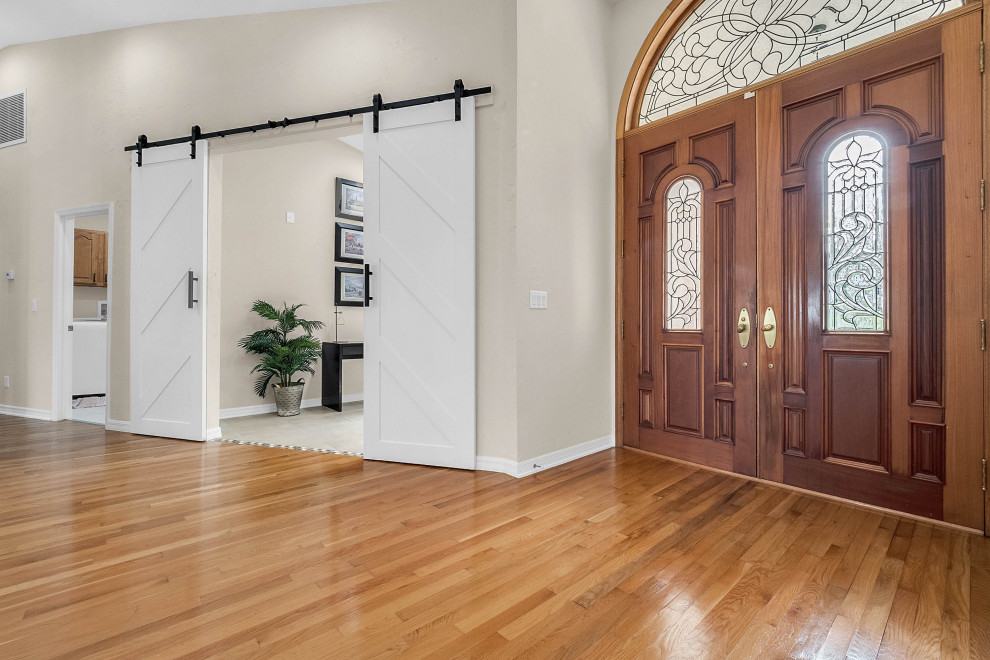 Ispirazione per una porta d'ingresso chic di medie dimensioni con pareti beige, pavimento in legno massello medio, una porta a due ante, una porta in legno bruno e pavimento marrone