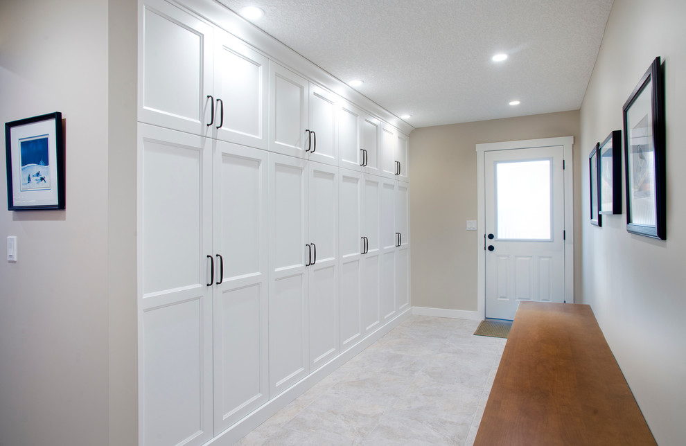 This is an example of a medium sized traditional boot room in Calgary with beige walls and ceramic flooring.