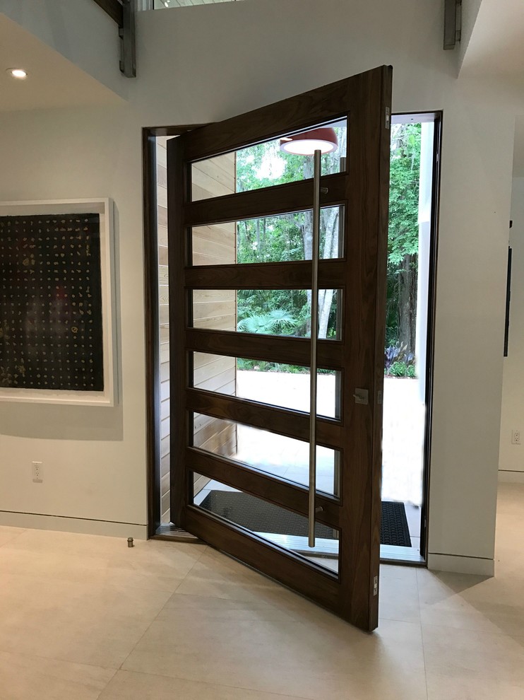 Esempio di una porta d'ingresso minimalista con una porta a pivot