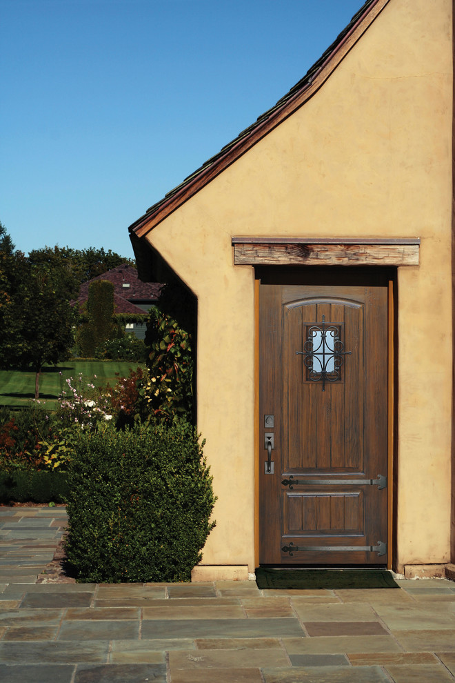Идея дизайна: входная дверь среднего размера в стиле рустика с желтыми стенами, полом из травертина, одностворчатой входной дверью и коричневой входной дверью