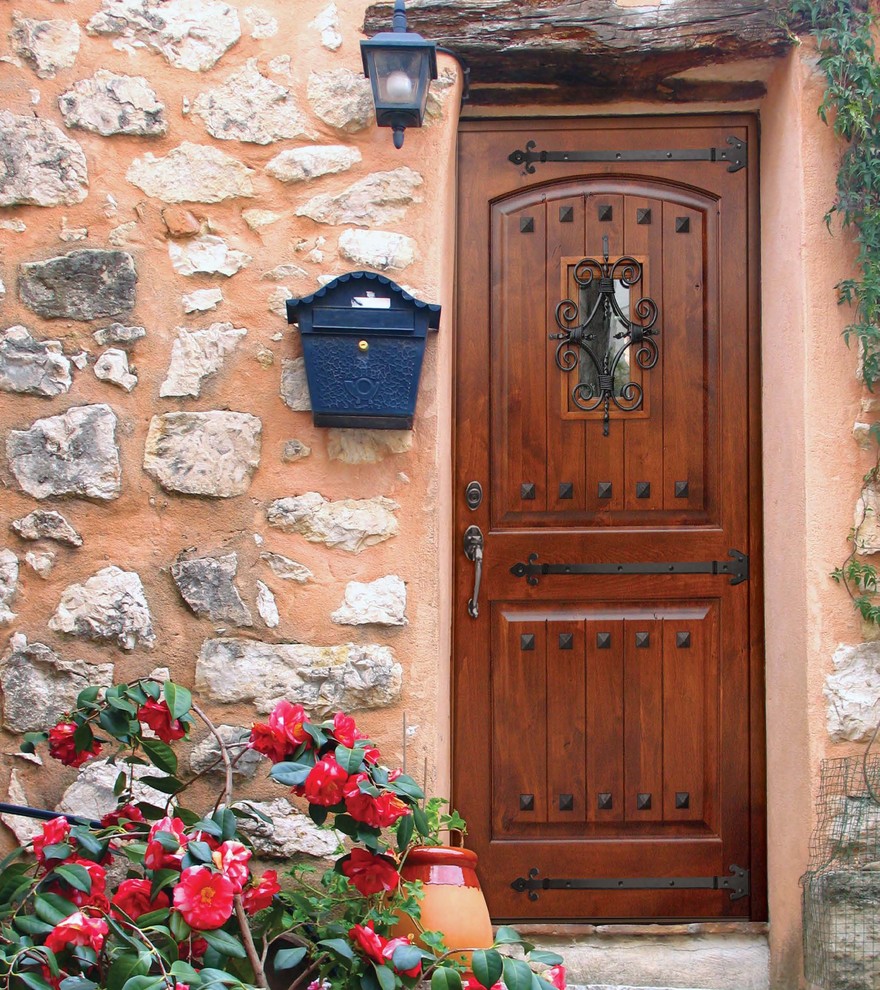 Exemple d'une petite porte d'entrée méditerranéenne avec un mur multicolore, une porte simple et une porte en bois brun.