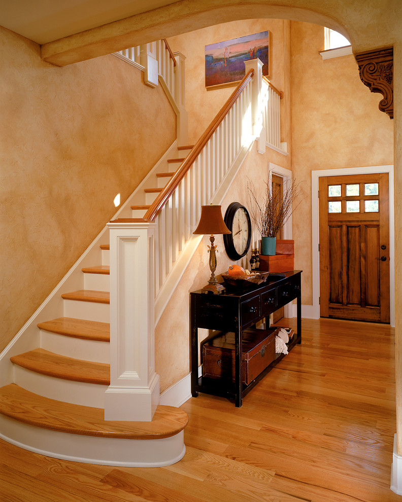 На фото: прихожая в классическом стиле с оранжевыми стенами, одностворчатой входной дверью и входной дверью из дерева среднего тона