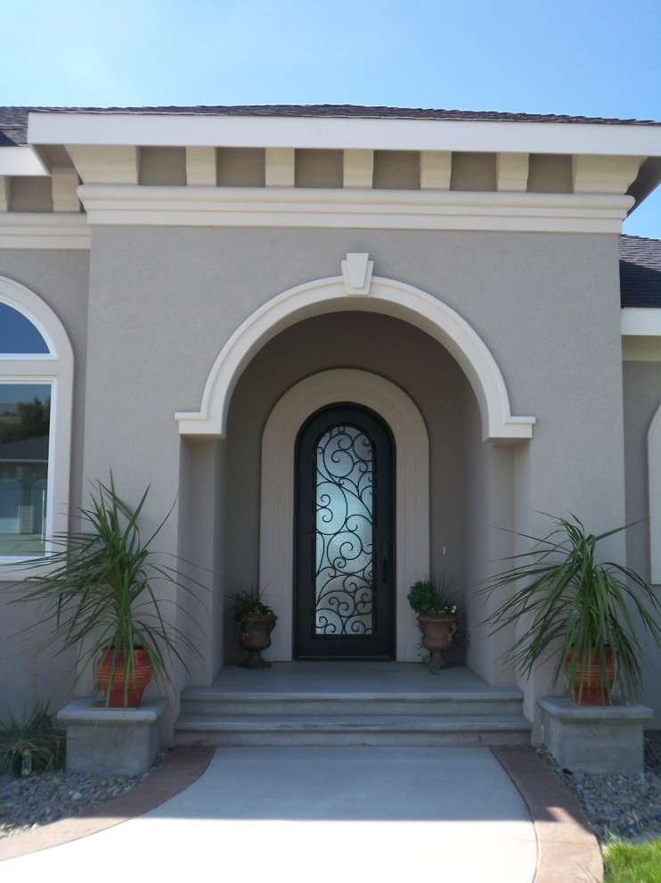 Ispirazione per una porta d'ingresso mediterranea di medie dimensioni con pareti beige, pavimento in cemento e una porta in metallo
