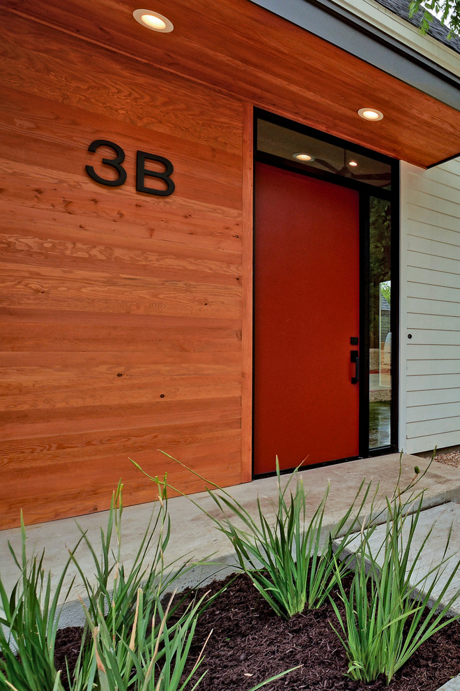 Пример оригинального дизайна: входная дверь в стиле модернизм с бетонным полом, одностворчатой входной дверью и красной входной дверью