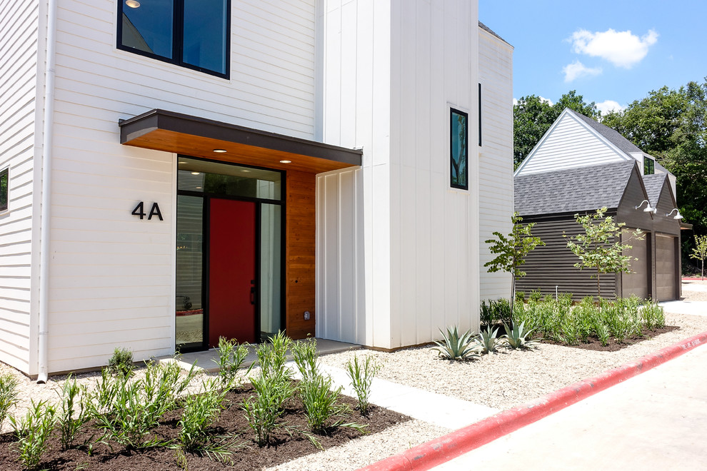 Example of a minimalist concrete floor single front door design in Austin with white walls and a red front door