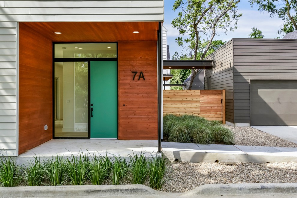 Immagine di una porta d'ingresso moderna di medie dimensioni con pavimento in cemento, una porta singola, una porta verde e pavimento grigio