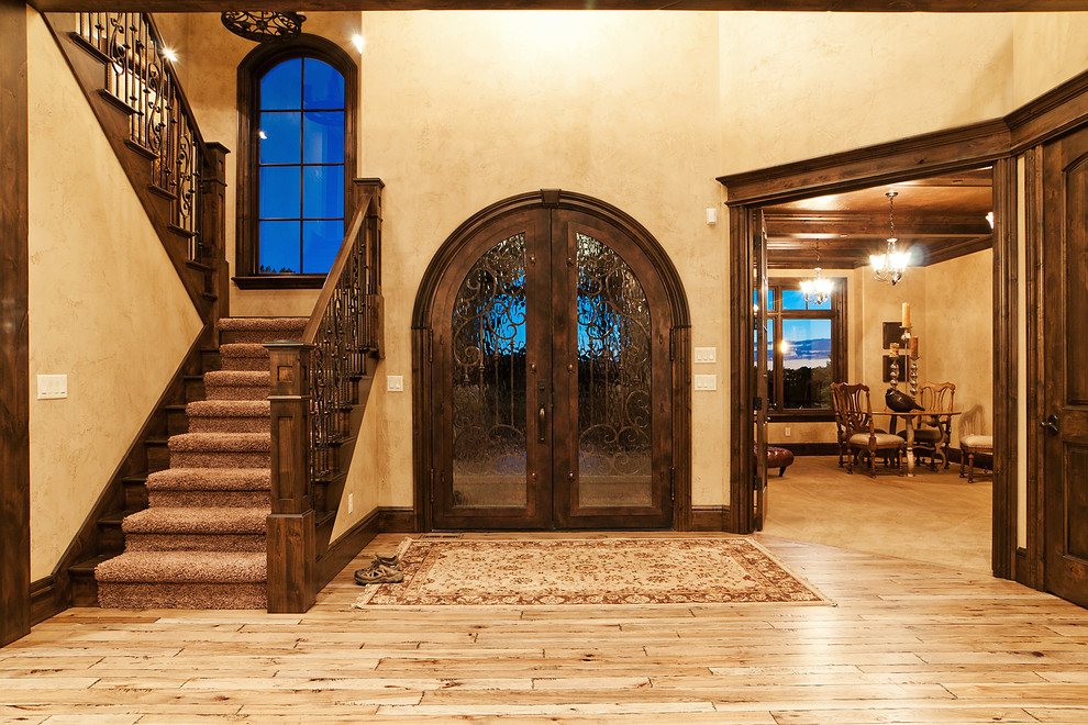 На фото: большая входная дверь в стиле рустика с бетонным полом, двустворчатой входной дверью и входной дверью из темного дерева с