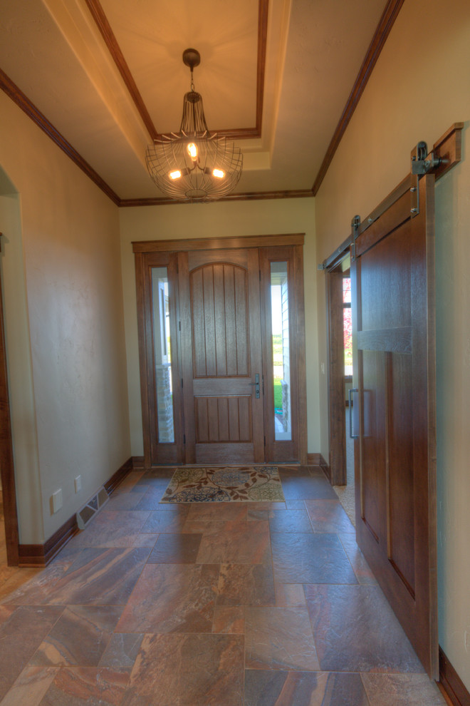 Classic hallway in Milwaukee with a single front door and a medium wood front door.