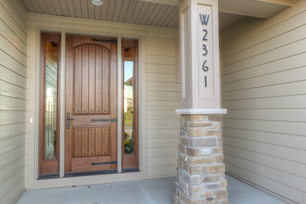 Aménagement d'une porte d'entrée craftsman avec une porte simple et une porte en bois brun.