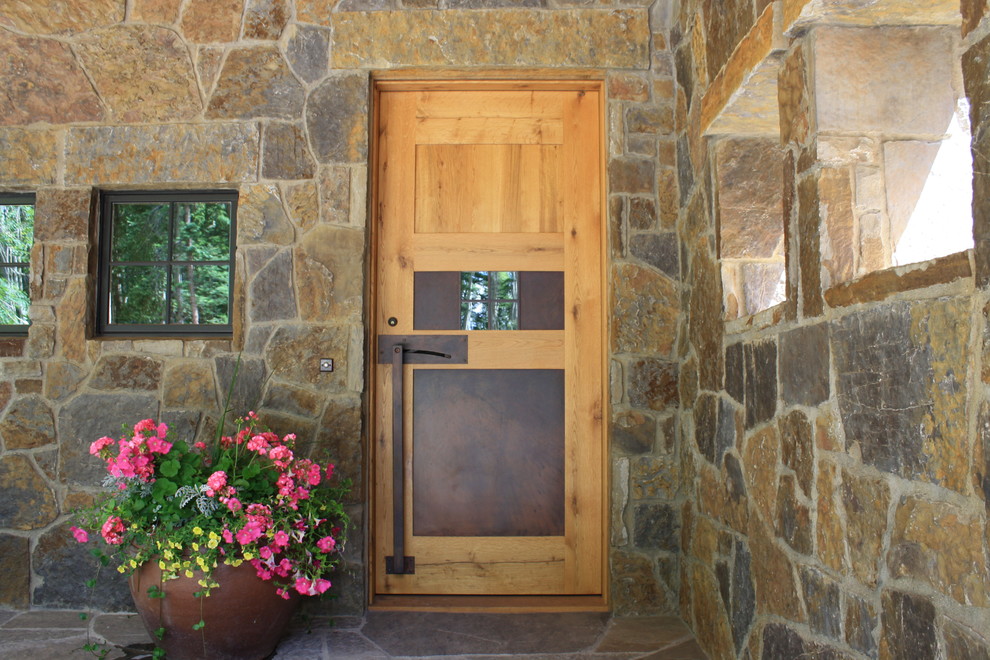 Immagine di una porta d'ingresso classica con una porta singola e una porta in legno bruno
