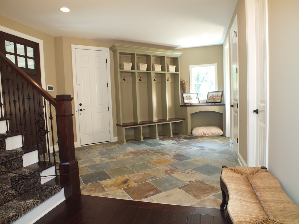 Photo of a large rustic boot room in Cleveland with beige walls, slate flooring and a dark wood front door.