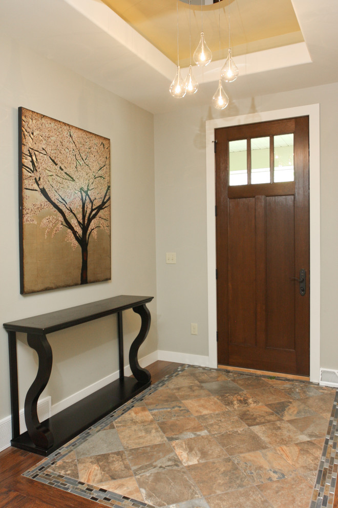 Idee per un corridoio chic di medie dimensioni con pareti grigie, pavimento con piastrelle in ceramica, una porta singola e una porta in legno bruno