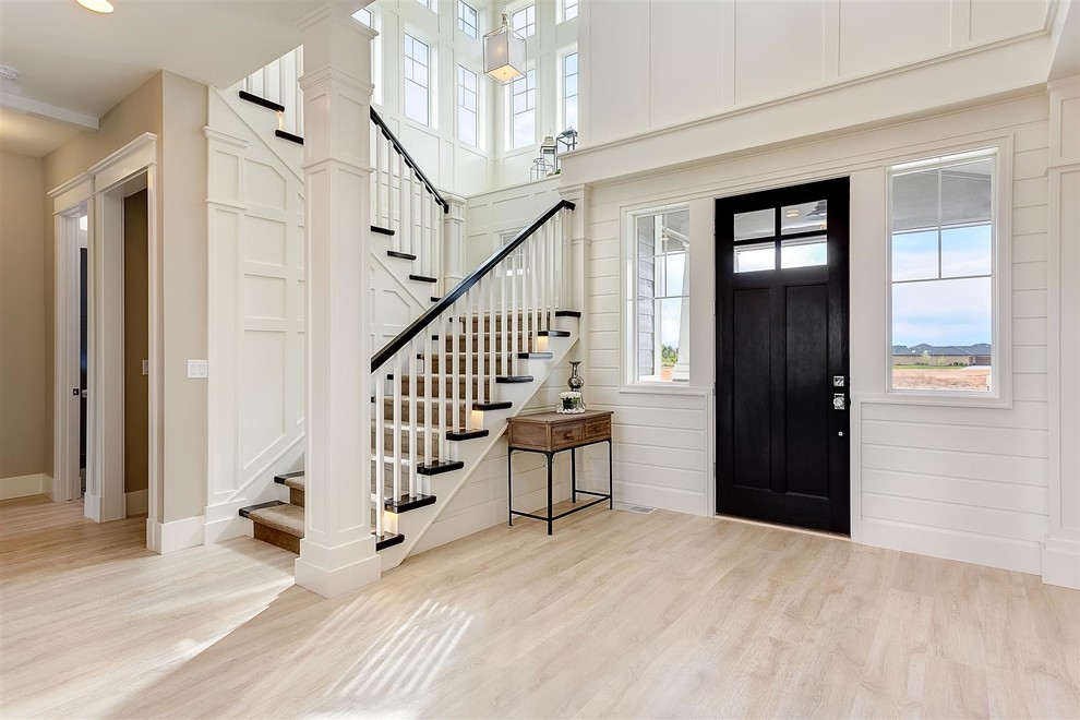 Photo of a large classic foyer in Boise with white walls, light hardwood flooring, a single front door and a black front door.