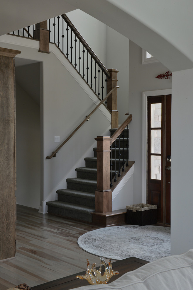 This is an example of a rustic entrance in Milwaukee with grey walls, medium hardwood flooring, a single front door and a dark wood front door.