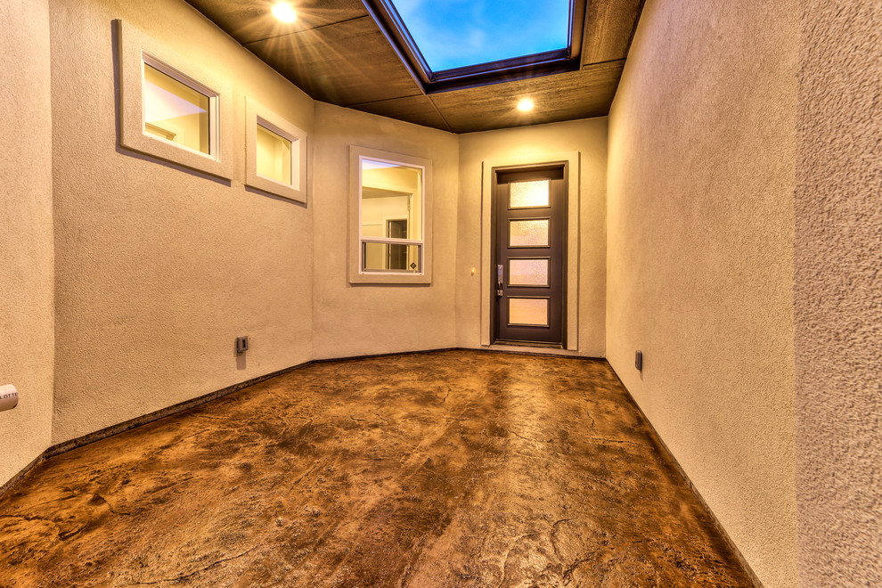 Inspiration for a mid-sized modern concrete floor entryway remodel in Boise with a dark wood front door