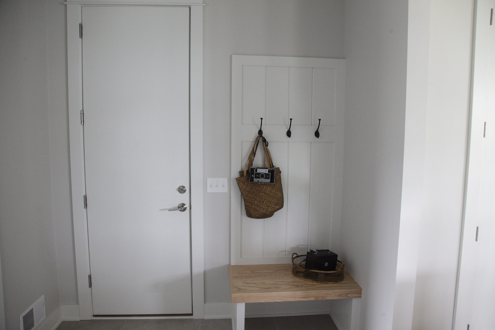 Idéer för mellanstora vintage kapprum, med grå väggar, klinkergolv i porslin, en enkeldörr och en vit dörr