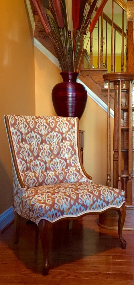 This is an example of a medium sized bohemian foyer in DC Metro with orange walls and dark hardwood flooring.