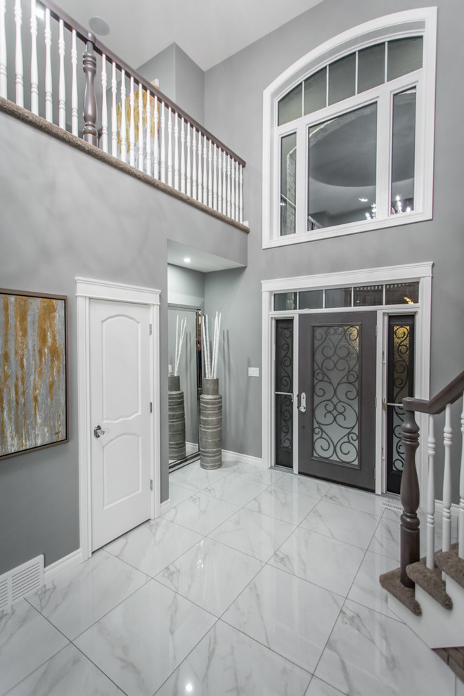 Cette photo montre un hall d'entrée moderne de taille moyenne avec un mur gris, un sol en marbre, une porte simple et une porte métallisée.