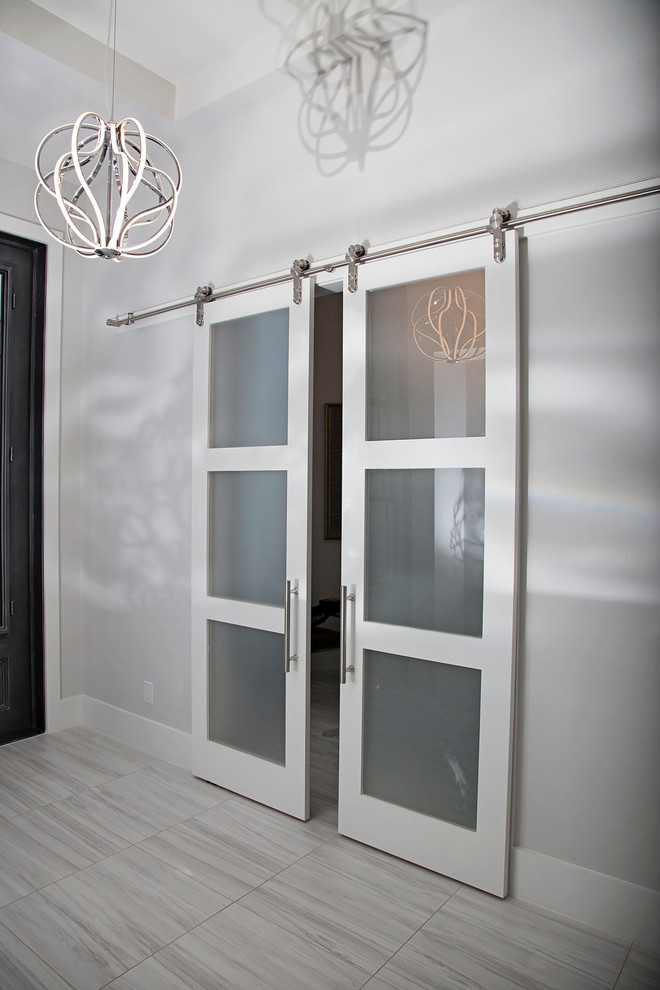 Großer Eingang mit grauer Wandfarbe, Marmorboden, Doppeltür und weißer Haustür in Miami