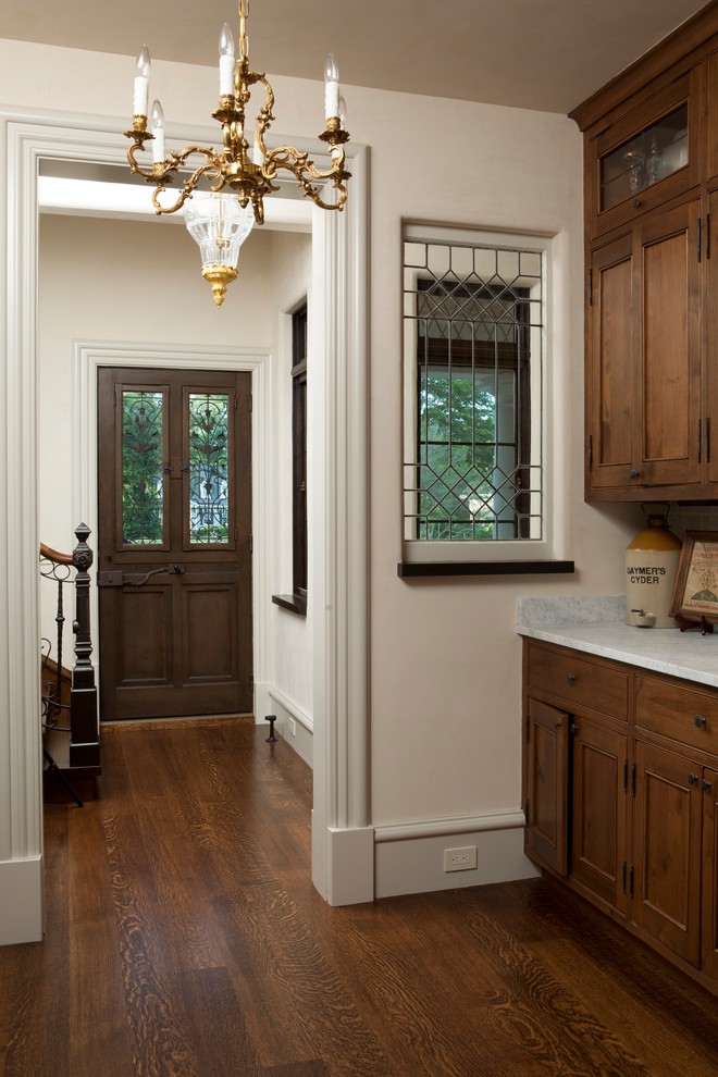 Foto de entrada ecléctica con paredes blancas, suelo de madera en tonos medios, puerta simple, puerta de madera oscura y suelo marrón