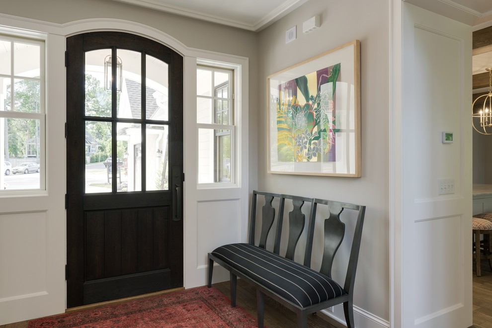 Imagen de puerta principal costera pequeña con paredes beige, suelo de madera en tonos medios, puerta simple, puerta marrón y suelo marrón