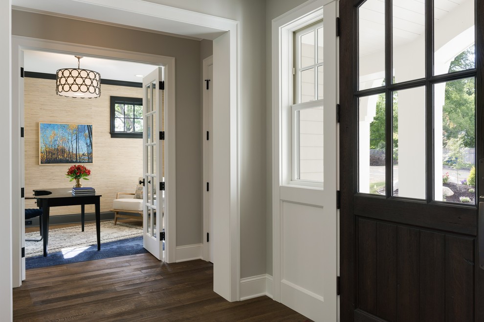 Ejemplo de puerta principal costera pequeña con paredes beige, suelo de madera en tonos medios, puerta simple, puerta marrón y suelo marrón