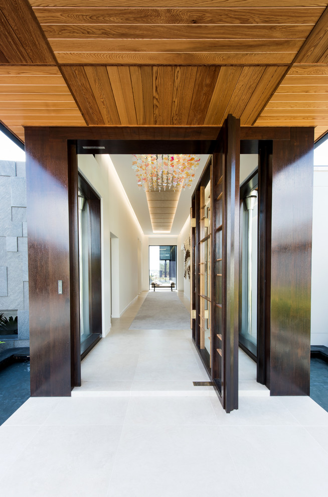 Immagine di una porta d'ingresso minimal con una porta a pivot e una porta in legno scuro