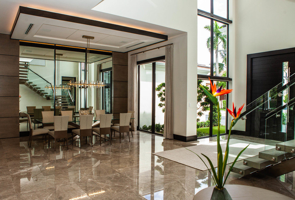Großer Moderner Eingang mit beiger Wandfarbe, Marmorboden, Einzeltür, dunkler Holzhaustür und braunem Boden in Miami