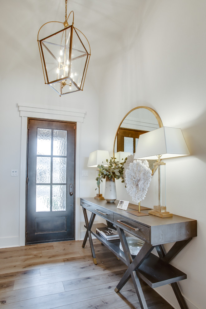 Inspiration for a medium sized farmhouse hallway in Austin with white walls, dark hardwood flooring, a single front door, a glass front door, brown floors and feature lighting.