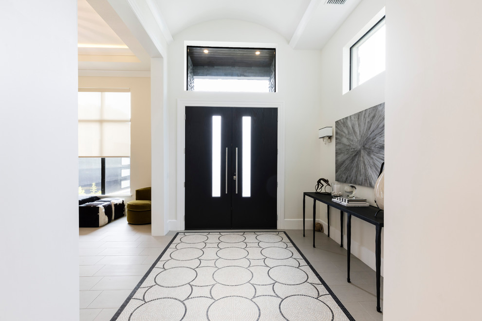На фото: фойе в современном стиле с белыми стенами, двустворчатой входной дверью, черной входной дверью и бежевым полом с
