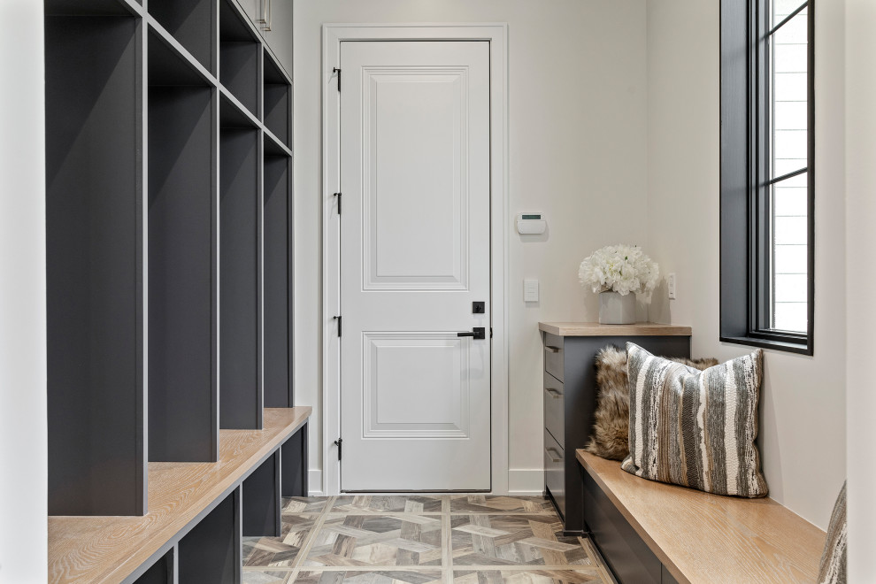 Example of a large trendy medium tone wood floor and brown floor mudroom design in Minneapolis with white walls